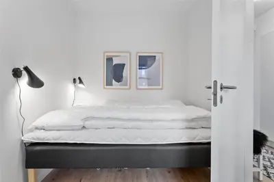 a bed in a bedroom with two pictures on the wall at 784-Thisted-Havstokken-30-A in Thisted