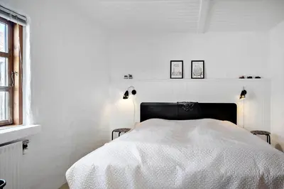 a white bedroom with a bed with a black headboard at 787-Thisted-Nordsovej-38 in Thisted