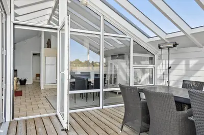 a conservatory with a table and chairs on a deck at 542-Thisted-Kuttervej-11 in Thisted