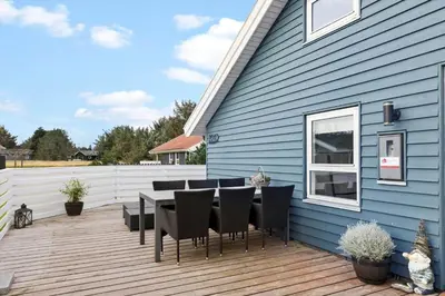 a patio with a table and chairs on a blue house at 144-Thisted-Nordsovej-204-D in Thisted