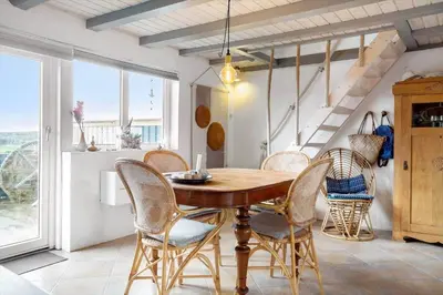 a dining room with a wooden table and chairs at 1012-Thisted-Trindbak-12-B in Torsted