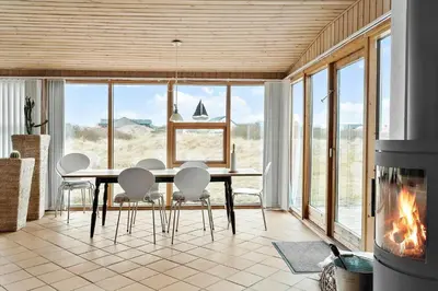 a dining room with a table and chairs and a fireplace at 529-Thisted-Nordsovej-24 in Thisted