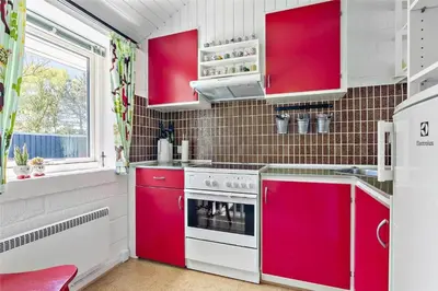a red and white kitchen with red cabinets at 344-Thisted-Flyndervej-20 in Thisted