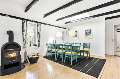 a dining room with a fireplace and a table and chairs at 344-Thisted-Flyndervej-20 in Thisted