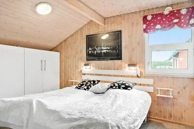 a bedroom with a bed and a tv on the wall at 860-Thisted-Gronnevej-6 in Thisted