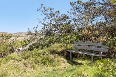 a wooden bench sitting on a hill in a field at 151-Thisted-Havbovej-39 in Thisted
