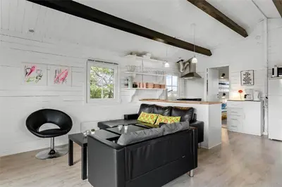 a living room with a black couch and a kitchen at 567-Thisted-Fiskervej-67 in Thisted
