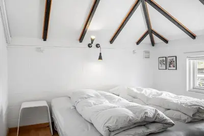 a bedroom with a bed with white sheets on it at 713-Thisted-Tranebaervej-10 in Thisted