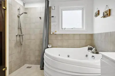 a white bath tub in a bathroom with a window at 1322-Snedsted-Lykkens-Hab-21 in Snedsted