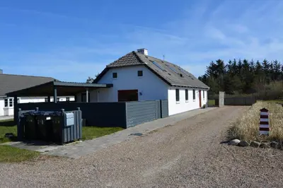 a white house with a fence next to a driveway at 1329-Thisted-Nordsovej-226 in Thisted