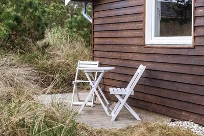 two white chairs and a table and a table and chairs next to a house at 1341-Thisted-Mose-Bolle-Vej-5 in Thisted