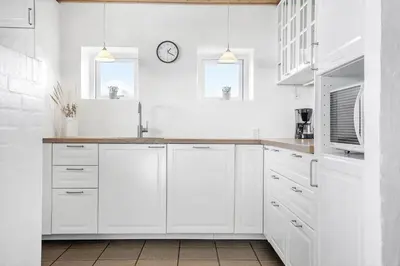 a kitchen with white cabinets and a clock on the wall at 1340-Thisted-Nordsovej-104 in Thisted