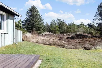 a yard with a wooden deck next to a house at 246-Thisted-Pighvarvej-16 in Thisted
