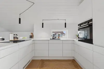 a white kitchen with white cabinets and black appliances at 1064-Thisted-Klitstien-25 in Torsted