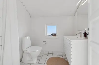 a white bathroom with a toilet and a sink at 1064-Thisted-Klitstien-25 in Torsted