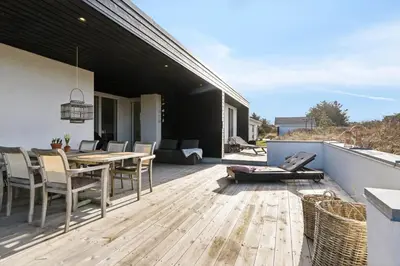 a wooden deck with a table and chairs on a house at 1064-Thisted-Klitstien-25 in Torsted