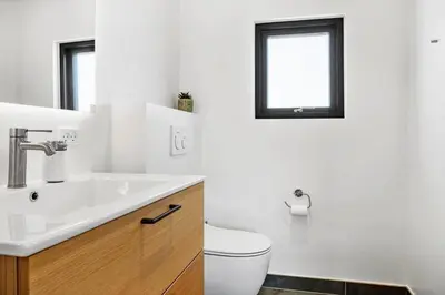 a bathroom with a sink and a toilet and a window at 1068-Thisted-Klovborgsti-5-A in Torsted