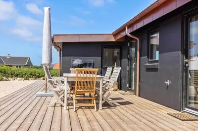 a wooden deck with a table and chairs on it at 1068-Thisted-Klovborgsti-5-A in Torsted