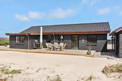 a house with a deck and chairs in front of it at 1068-Thisted-Klovborgsti-5-A in Torsted