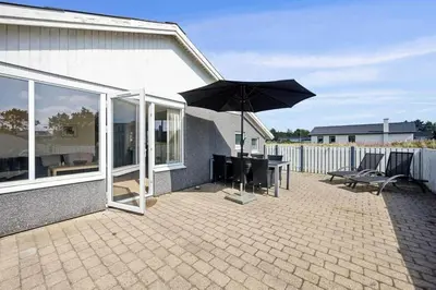 a patio with an umbrella and a table and chairs at 148-Thisted-Fiskervej-74 in Thisted