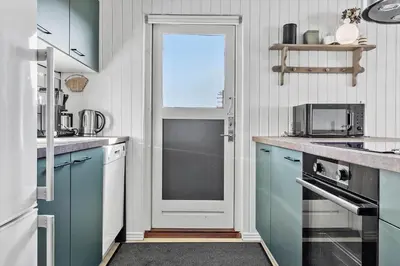 a kitchen with blue cabinets and a door at 148-Thisted-Fiskervej-74 in Thisted