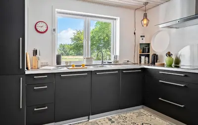 a kitchen with black cabinets and a window at 4 Bedroom Nice Home In Bedsted Thy in Bedsted Thy