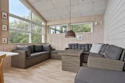 a living room with couches and a table and windows at 1351-Thisted-Mose-Bollevej-13 in Thisted