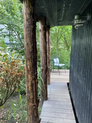 a wooden walkway with a tree in the middle at Lykkeholms Bella Vista in Spottrup