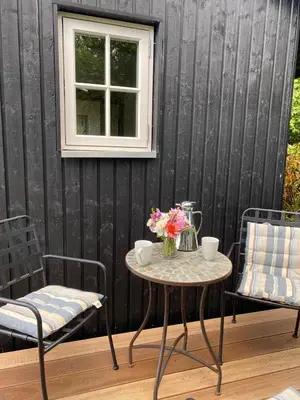 a table with a vase of flowers and two chairs at Lykkeholms Bella Vista in Spottrup