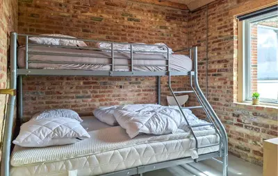a bunk bed with two pillows on a brick wall at 3 Bedroom Amazing Home In Erslev in Erslev