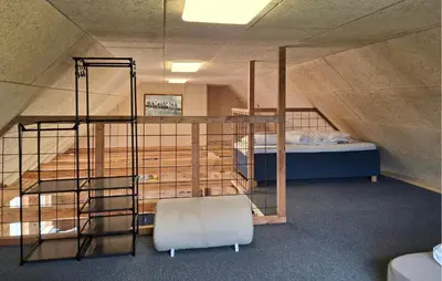 a room with a bunk bed and a chair in a attic at 3 Bedroom Amazing Home In Erslev in Erslev