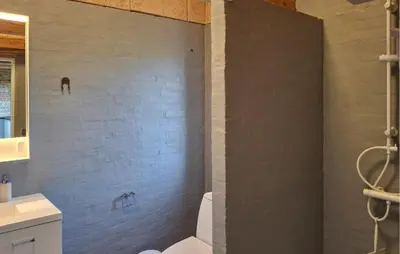 a bathroom with a white toilet and a brick wall at 3 Bedroom Amazing Home In Erslev in Erslev