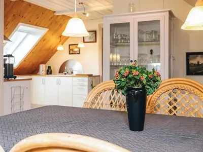 a dining room table with a vase of flowers on it at 6 person holiday home in Thisted in Thisted
