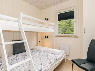 a bedroom with a bunk bed and a ladder at 5 person holiday park home in Pandrup in Pandrup