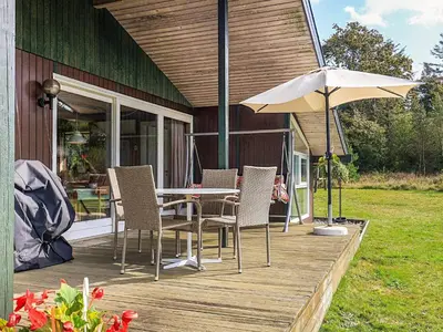 a table and chairs and an umbrella on a deck at 8 person holiday home in Skals-By Traum in Skals