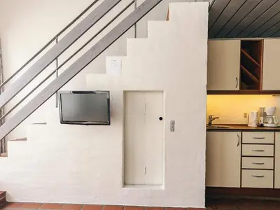 a room with a staircase with a door and a tv at 6 person holiday home in Brovst in Brovst