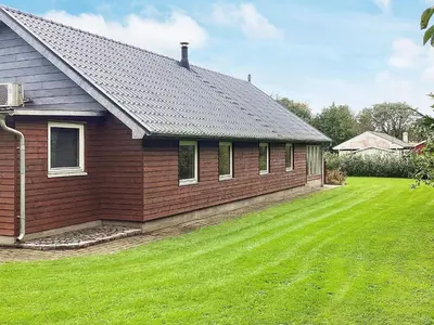 a house with a grass yard next to a house at 4 star holiday home in Farsø-By Traum in Farsø