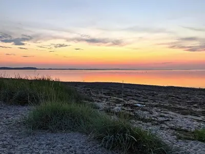 a beach with a sunset in the background at 4 star holiday home in Farsø-By Traum in Farsø