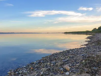 a large body of water with a rocky shore at 4 star holiday home in Farsø-By Traum in Farsø