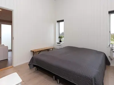 a bedroom with a bed and two windows at 8 person holiday home in Saltum-By Traum in Saltum