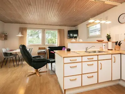 a kitchen with a sink and a chair and a table at 5 person holiday home in Thyholm-By Traum in Thyholm