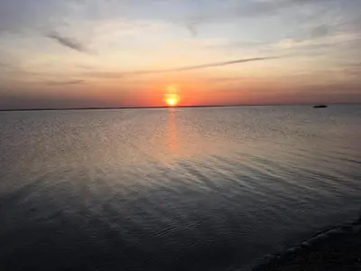 a sunset over the water with a boat in the distance at 6 person holiday home in Vinderup-By Traum in Vinderup