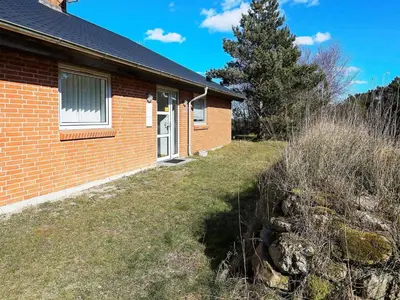 a red brick house with a tree in front of it at 8 person holiday home in Thyholm-By Traum in Thyholm