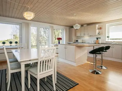 a kitchen and dining room with a white table and chairs at 8 person holiday home in Thyholm-By Traum in Thyholm