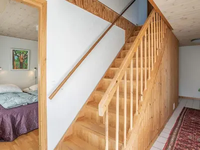 a wooden staircase in a bedroom with a bed at 8 person holiday home in Thyholm-By Traum in Thyholm