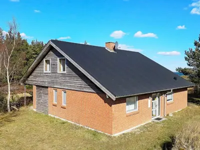 a red brick house with a black roof at 8 person holiday home in Thyholm-By Traum in Thyholm