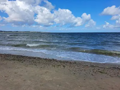 a beach with the ocean on a cloudy day at 6 person holiday home in Struer-By Traum in Struer