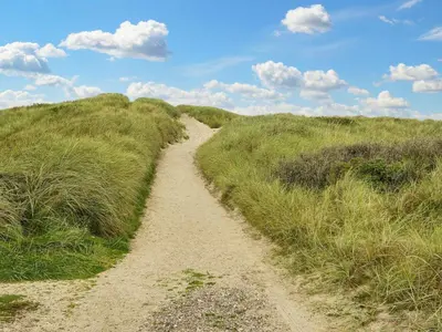 a dirt path through a grassy hill with a blue sky at 10 person holiday home in Harboøre-By Traum in Harboør