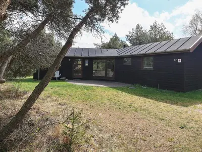 a black house with a large yard in front of it at 8 person holiday home in Fjerritslev-By Traum in Fjerritslev