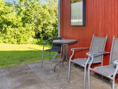 two chairs and a table and two chairs next to a building at 5 person holiday home in Roslev-By Traum in Roslev